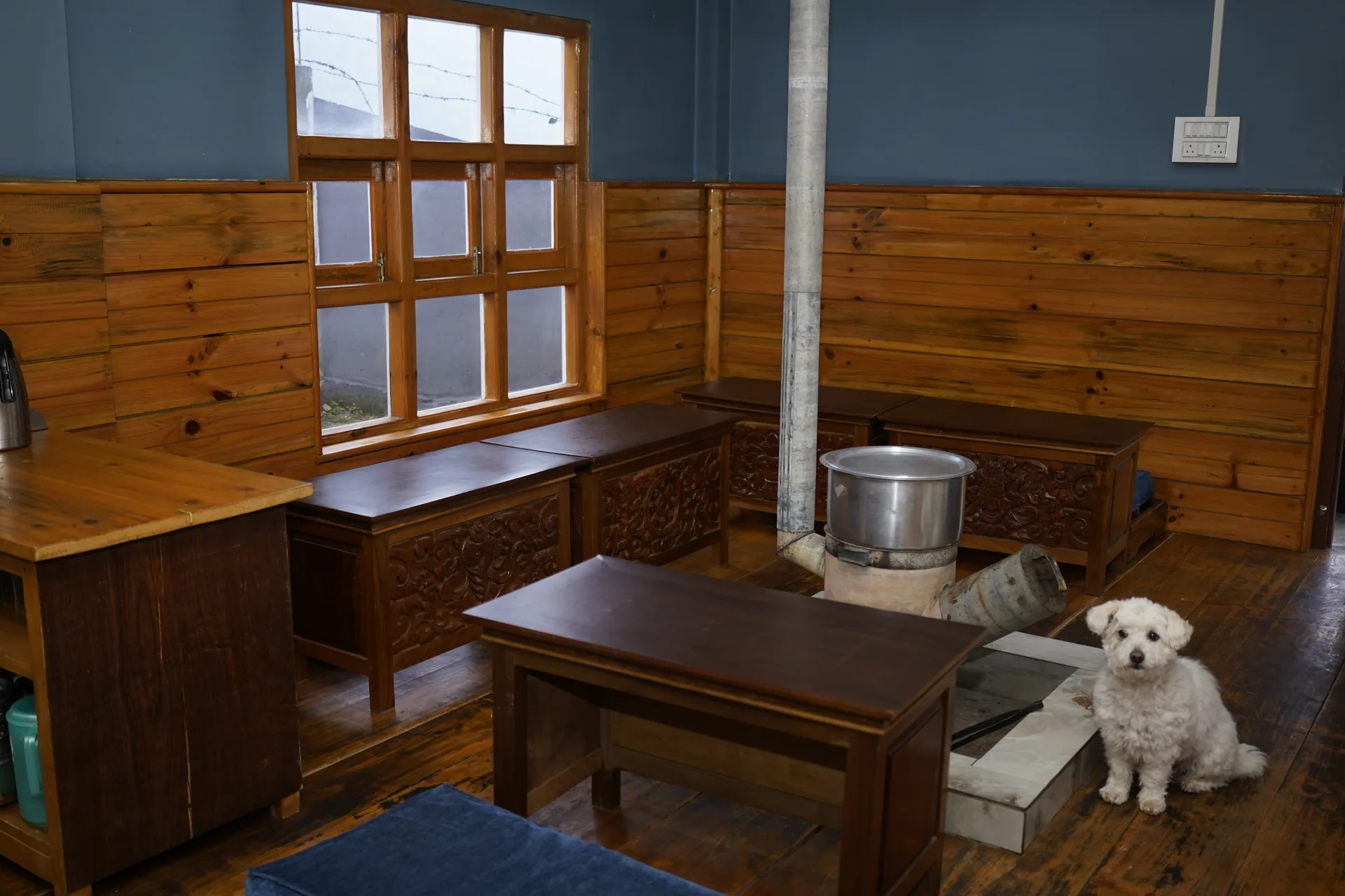 Common dining area with traditional wood stove at Acorn Homestay