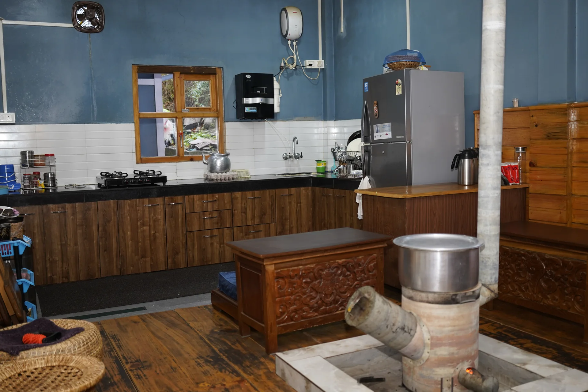 Kitchen interior with traditional wood stove at Acorn Homestay