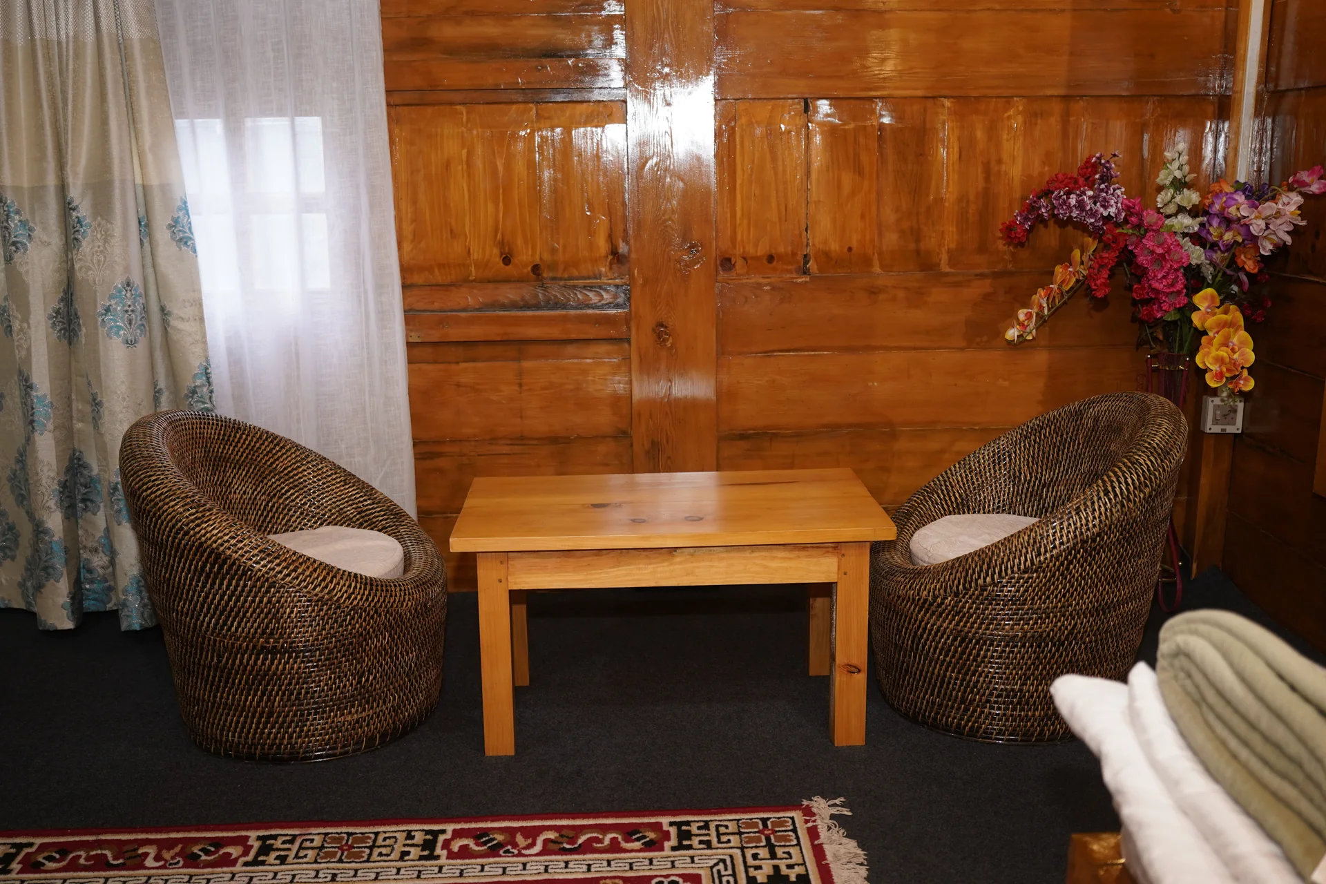 Room sitting area with wicker chairs at Acorn Homestay